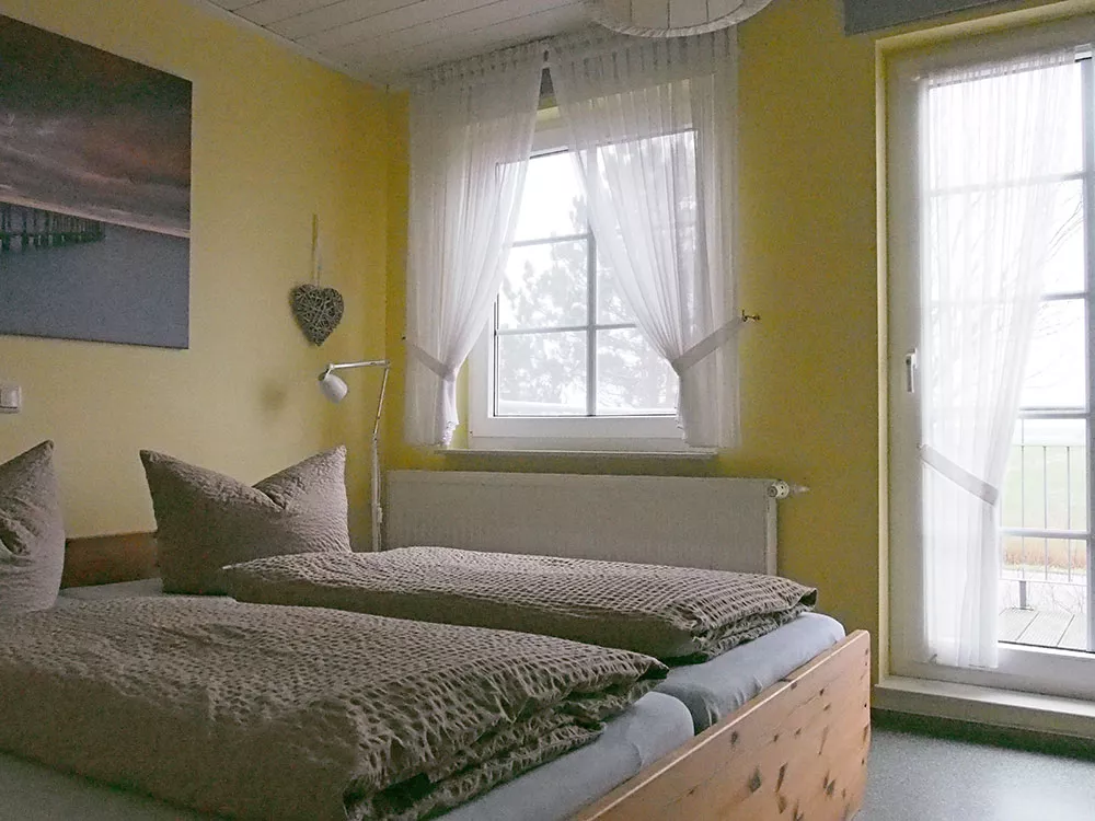 Schlafzimmer Ferienwohnung 2 – Doppelbett, helles Fenster