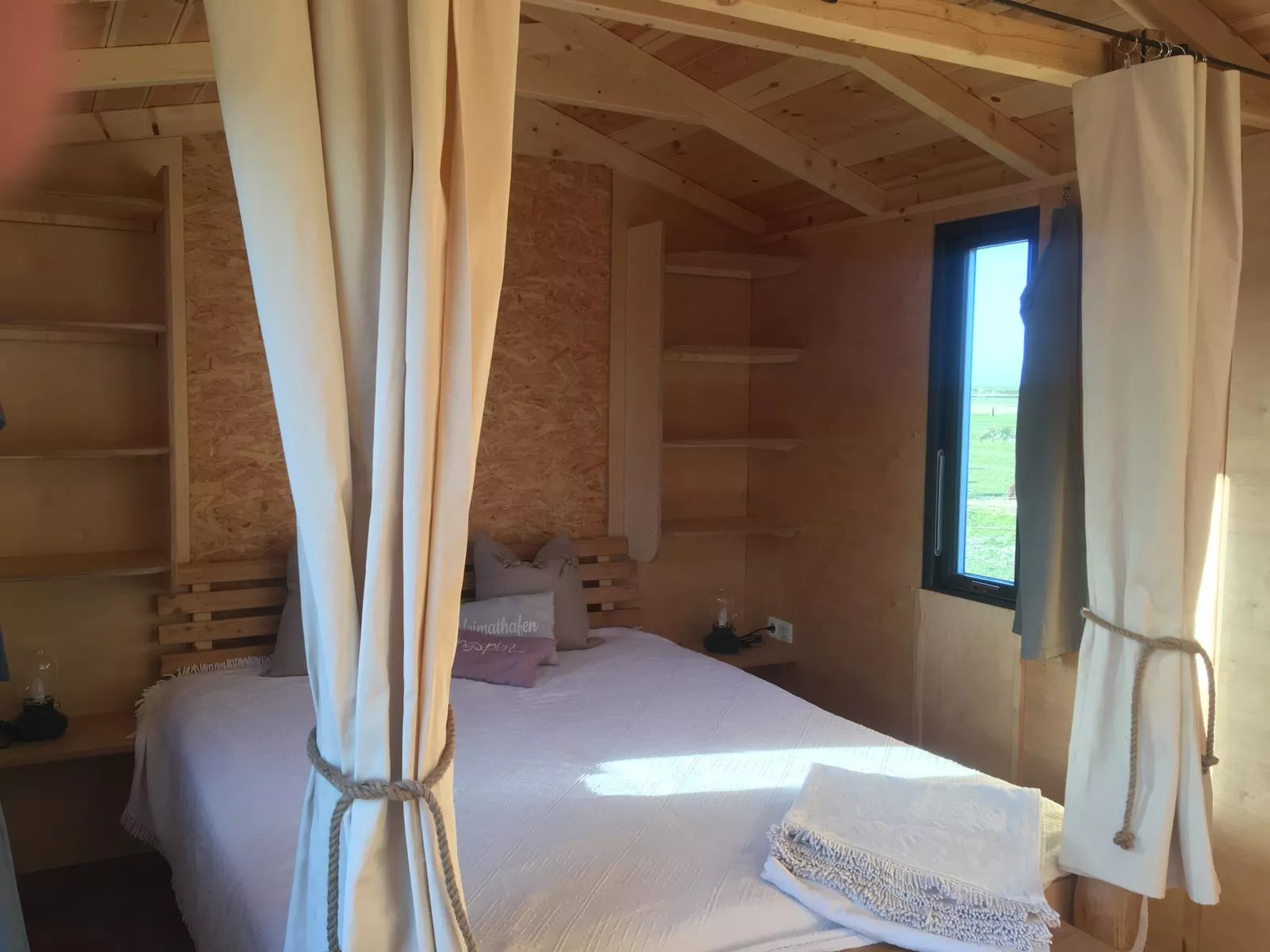 Bett mit Fenster ins Grüne