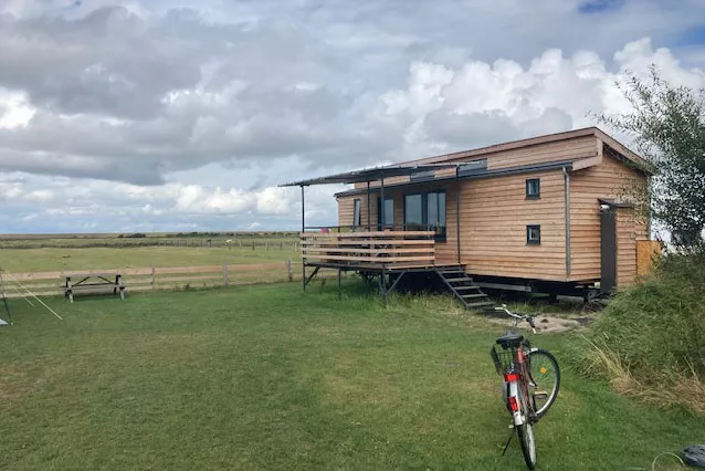 Schäferwagen inmitten der Natur mit einem davor parkenden Fahrrad