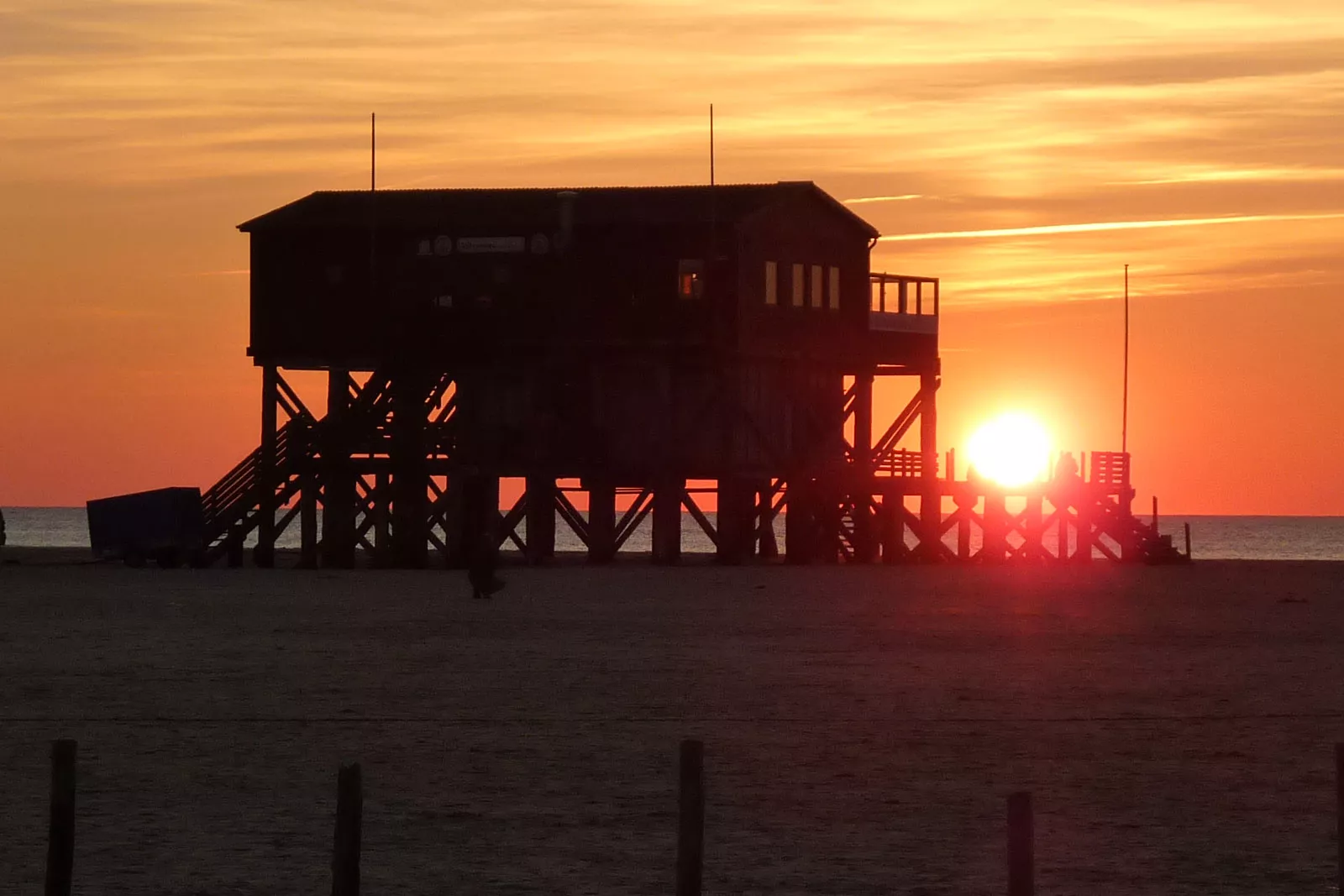Sonnenuntergang am Strand von St. Peter-Ording mit Pfahlbauten