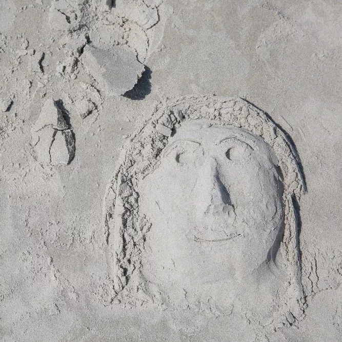 Figur im Sand am Strand